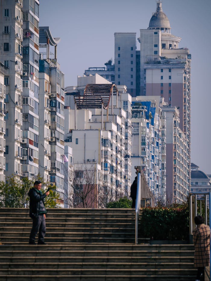 Vibrant urban scene with high-rise buildings and people on stairs capturing the city's essence.